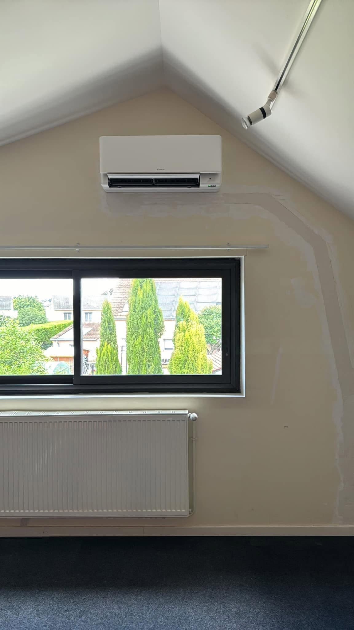Unité intérieure de climatisation Daikin posée sous pente dans un comble aménagé par CT elec, Marne