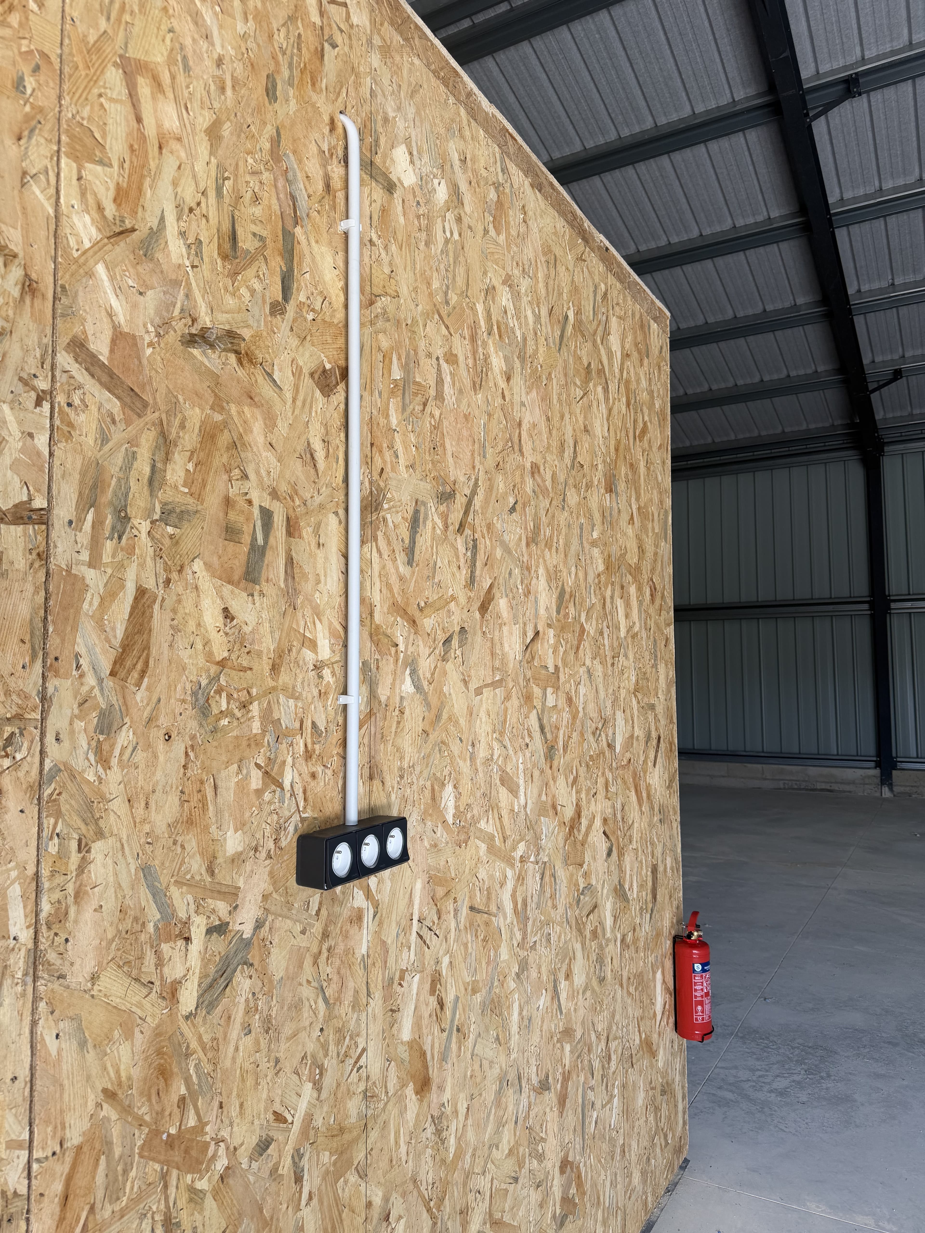 Éclairage d'atelier avec spots LED et alimentation verticale apparente sur mur OSB par CT elec, Marne